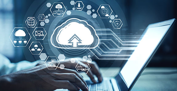 Notebook, Hände tippen auf der Tastatur. Darüber schwebt im virtuellen Raum eine Wolke mit einem Uplod-Symobl nach oben. Um die Wolke bewegen sich weitere Icons als Satelitten.