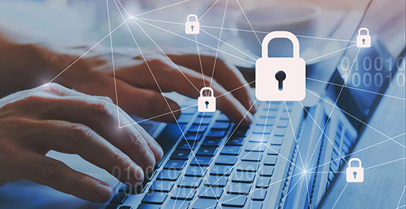 Notebook, Hände tippen auf der Tastatur. Darüber schwebt ein virtuelles Netz mit Schloss-Symoblen.